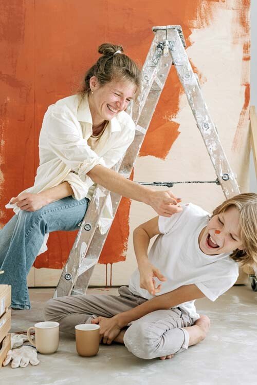 Mama en zoon aan het schilderen in huis